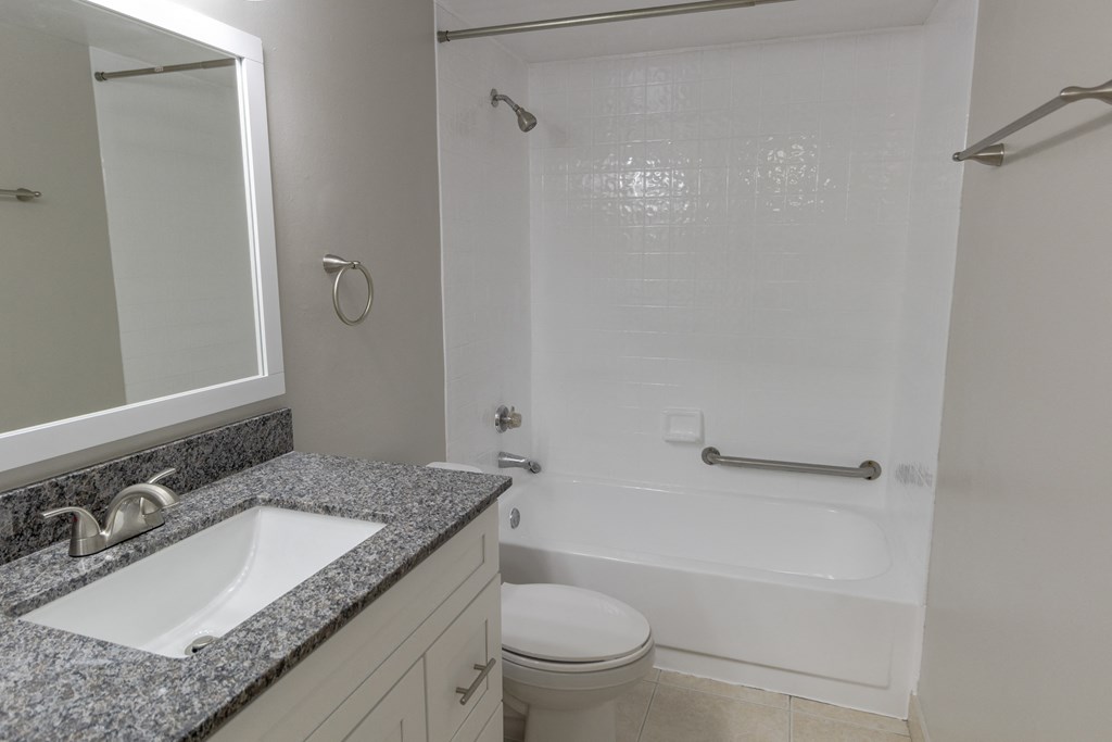 A white bathroom with a sink, toilet and bathtub.
